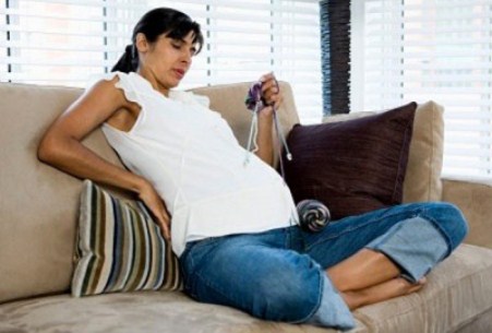 беременная сидит на диване